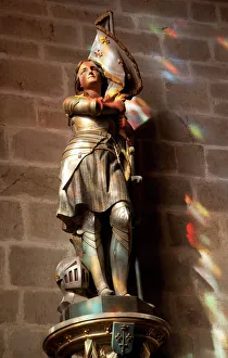 Statue of St. Joan of Arc with coloured light from stained glass, Church of Notre Dame Statue of St. Joan of Arc with coloured light from stained glass, Church of Notre Dame