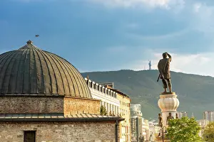 Prints of Stone building with dome and statue of man holding sword in Skopje against mountain backdrop North Macedonia Prints: Stone building with dome and statue in Skopje print
