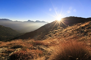 Sunbeams on alpine pastures with peak Scalino in the background, Val Torreggio, Malenco Valley Sunbeams on alpine pastures with peak Scalino in the background, Val Torreggio, Malenco Valley