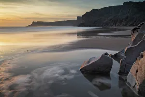 Sunset over a deserted Mewslade Bay in Gower in winter, South Wales, United Kingdom Sunset over a deserted Mewslade Bay in Gower in winter, South Wales, United Kingdom