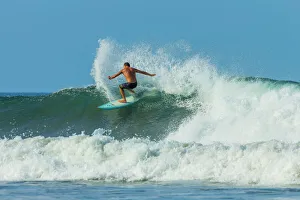 Surfer on shortboard riding wave at popular Playa Guiones surf beach, Nosara, Nicoya Peninsula, Guanacaste Province Surfer on shortboard riding wave at popular Playa Guiones surf beach, Nosara, Nicoya Peninsula, Guanacaste Province