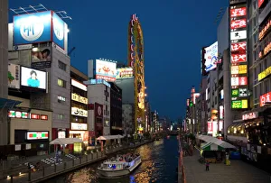 Tour boat on Dotonbori River glides past shops and restaurants in Namba Tour boat on Dotonbori River glides past shops and restaurants in Namba