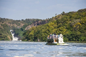Tourist boat cruising the Nile in front of the Murchison Falls (Kabarega Falls) on the Nile Tourist boat cruising the Nile in front of the Murchison Falls (Kabarega Falls) on the Nile