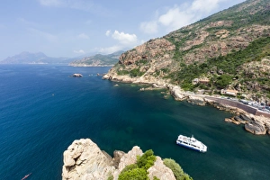 Tourist boat in the turquoise sea framed by limestone cliffs, Porto, Southern Corsica Tourist boat in the turquoise sea framed by limestone cliffs, Porto, Southern Corsica