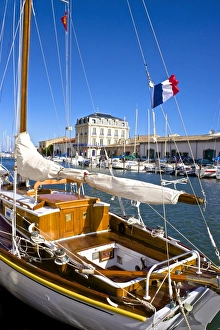 Tourist boats in marina, and French flag, in Marseillan harbor, Herault, Languedoc-Roussillon region, France, Europe Tourist boats in marina, and French flag, in Marseillan harbor, Herault, Languedoc-Roussillon region, France, Europe