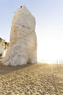 Towering white rock monolith Pizzomunno at sunrise, Vieste, Foggia province Towering white rock monolith Pizzomunno at sunrise, Vieste, Foggia province