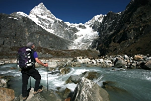 A trekker pauses for a break on the edge of a glacial stream on the way to Mera Peak A trekker pauses for a break on the edge of a glacial stream on the way to Mera Peak