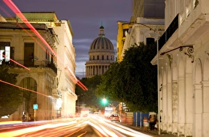 View towards the Capitolio at dusk with light trails of traffic on a busy street View towards the Capitolio at dusk with light trails of traffic on a busy street