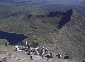 Walkers relaxing at the summit of Mount Snowdon, with Llyn Llydaw reservoir Walkers relaxing at the summit of Mount Snowdon, with Llyn Llydaw reservoir