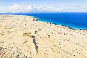Images Dated 18th May 2021: White sand dunes meeting the blue Atlantic Ocean, aerial view, Corralejo Nature Park
