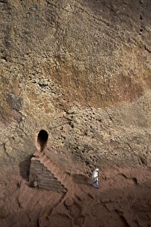 A woman emerges from a tunnel leading to the rock-hewn church of Bet Amanuel A woman emerges from a tunnel leading to the rock-hewn church of Bet Amanuel