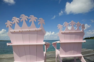 Wooden pink beach chairs with backs carved in the shape of palm trees Wooden pink beach chairs with backs carved in the shape of palm trees