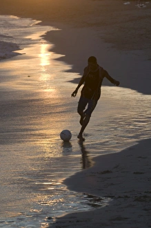 Young man playing football at sandbeach in twilight, Santa Maria, Sal, Cape Verde, Africa Young man playing football at sandbeach in twilight, Santa Maria, Sal, Cape Verde, Africa