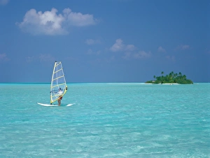 Young man windsurfing near tropical island and lagoon in the Maldives, Indian Ocean Young man windsurfing near tropical island and lagoon in the Maldives, Indian Ocean