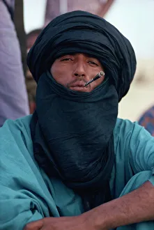 Young Tuareg man smoking small pipe and wearing headscarf, Timbuktu, Mali, West Africa Young Tuareg man smoking small pipe and wearing headscarf, Timbuktu, Mali, West Africa