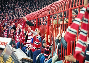 Manchester United fans hold their scarves through fences at the Stretford End in 1977 Manchester United fans hold their scarves through fences at the Stretford End in 1977