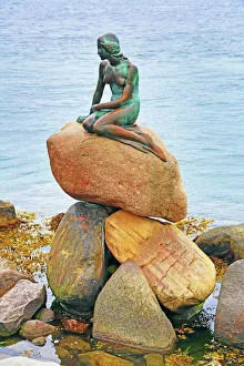 Little Mermaid statue sitting on rocks in Copenhagen, Denmark