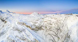 Aerial panoramic of Stelvio Pass and winding road covered with snow at dawn, Bormio Aerial panoramic of Stelvio Pass and winding road covered with snow at dawn, Bormio