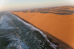 Aerial view over sand dunes & sea, Namib Desert, Namibia Aerial view over sand dunes & sea, Namib Desert, Namibia