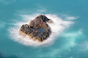 Portugal Collection: Aerial view of small rock island amongst waves, Madeira, Portugal
