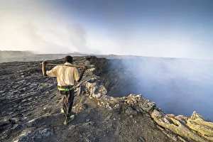 Afar man looking at the smoke coming out from Erta Ale volcano caldera Afar man looking at the smoke coming out from Erta Ale volcano caldera