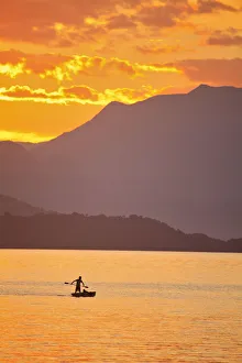 Brazil, Rio de Janeiro State, Angra dos Reis, Ilha Grande, a fisherman silhouetted Brazil, Rio de Janeiro State, Angra dos Reis, Ilha Grande, a fisherman silhouetted