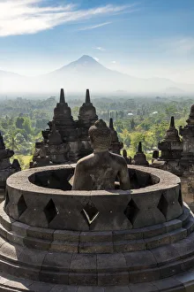 Buddha Statue Indonesia Prints: Buddha statue with Mount Merapi in the background, Candi Borobudur buddhist temple