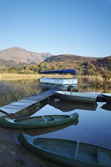 Canoes on lake with Drakensberg mountains in background, Ukhahlamba-Drakensberg Park Canoes on lake with Drakensberg mountains in background, Ukhahlamba-Drakensberg Park