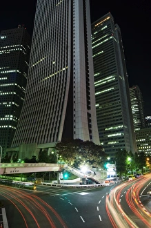 Car light trails under skyscrapers and city buildings Car light trails under skyscrapers and city buildings