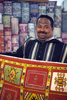 A carpet salesman displays his wares in the souq of Marrakesh A carpet salesman displays his wares in the souq of Marrakesh