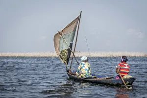 two colorfully dressed local women in wooden sailing canoe on the lake two colorfully dressed local women in wooden sailing canoe on the lake