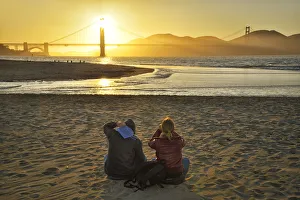 Couple watching sunset at Golden Gate Bridge, Crissy Field, San Francisco, California Couple watching sunset at Golden Gate Bridge, Crissy Field, San Francisco, California