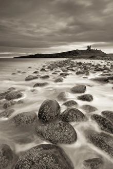 Dunstanburgh Castle at dawn from Embleton Bay, Northumberland, England. Spring (April) Dunstanburgh Castle at dawn from Embleton Bay, Northumberland, England. Spring (April)