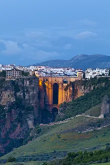 Elevated view over Puento Nuevo & the White Village of Ronda illuminated at dusk, Ronda Elevated view over Puento Nuevo & the White Village of Ronda illuminated at dusk, Ronda