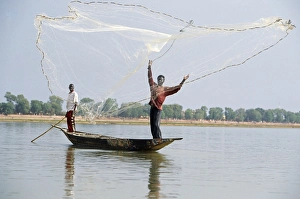 Fisherman cast hand nets on the River Niger from shallow-draught boats Fisherman cast hand nets on the River Niger from shallow-draught boats