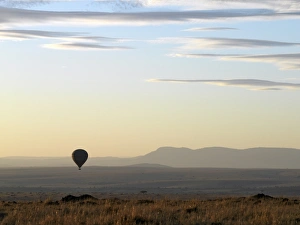 A hot air balloon floating over the Masai Mara Game Reserve at daybreak A hot air balloon floating over the Masai Mara Game Reserve at daybreak