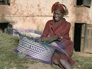 A Malagasy woman weaves a basket from raffia palm A Malagasy woman weaves a basket from raffia palm