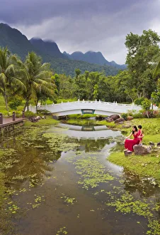 Malaysia, Langkawi, Oriental Gardens, Woman and girl sitting by lake MR Malaysia, Langkawi, Oriental Gardens, Woman and girl sitting by lake MR