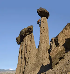 Man climbing up on Hoodoo, Balanced Rocks, Jefferson County, near Lake Billy Chinook Man climbing up on Hoodoo, Balanced Rocks, Jefferson County, near Lake Billy Chinook