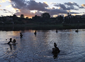 Men fish in Antsirabes lake at dusk using traditional Men fish in Antsirabes lake at dusk using traditional