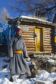 Mongolia, Ovorkhangai, Orkhon Valley. A Mongolian man stands by a hut at hot springs Mongolia, Ovorkhangai, Orkhon Valley. A Mongolian man stands by a hut at hot springs