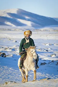 Mongolia, Ovorkhangai, Orkkhon Valley. A man approaches on horseback at sunrise Mongolia, Ovorkhangai, Orkkhon Valley. A man approaches on horseback at sunrise