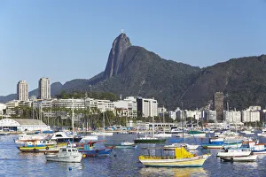 Moored boats in harbour with Christ the Redeemer statue in background, Urca, Rio de Moored boats in harbour with Christ the Redeemer statue in background, Urca, Rio de