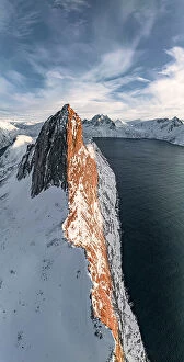 Q3 2023 Collection: Overhead view of steep ridge of Segla mountain covered with snow at sunset, aerial view, Senja