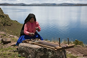 Peru, A Quechua-speaking woman works her traditional wooden loom on Taquile Island Peru, A Quechua-speaking woman works her traditional wooden loom on Taquile Island