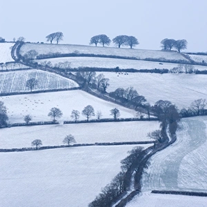 Snow covered winding country lane and rural landscape near Stockleigh Pomeroy, Mid Devon, England Snow covered winding country lane and rural landscape near Stockleigh Pomeroy, Mid Devon, England