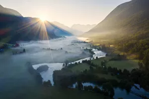 Norway Collection: Sunburst during a foggy sunrise over Stryneelva river and fields, aerial view, Stryn