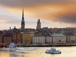 Sweden, Stockholm, Riddarfjarden, Gamla Stan; passenger ferries in bay at dusk Sweden, Stockholm, Riddarfjarden, Gamla Stan; passenger ferries in bay at dusk
