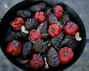 Thick steaks and whole red peppers cooked on an open fire at Kwandwe Lodge Thick steaks and whole red peppers cooked on an open fire at Kwandwe Lodge