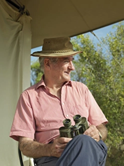 A tourist watches birds and animals from the verandah A tourist watches birds and animals from the verandah